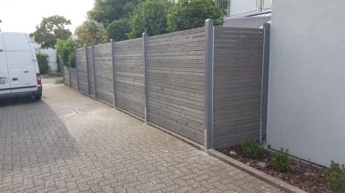 Ein Zaun aus Holz in Grau lasiert